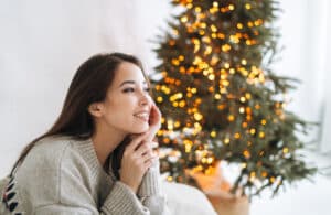 smiling woman by christmas tree